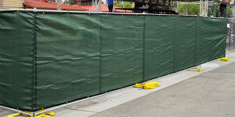 Moveable fence panels near Fowler with green privacy screen surrounding a music stage.