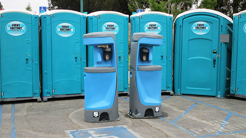 A row of blue portable toilets with blue hand wash stations in front, some of the best portable bathrooms for rent near Burbank, California.